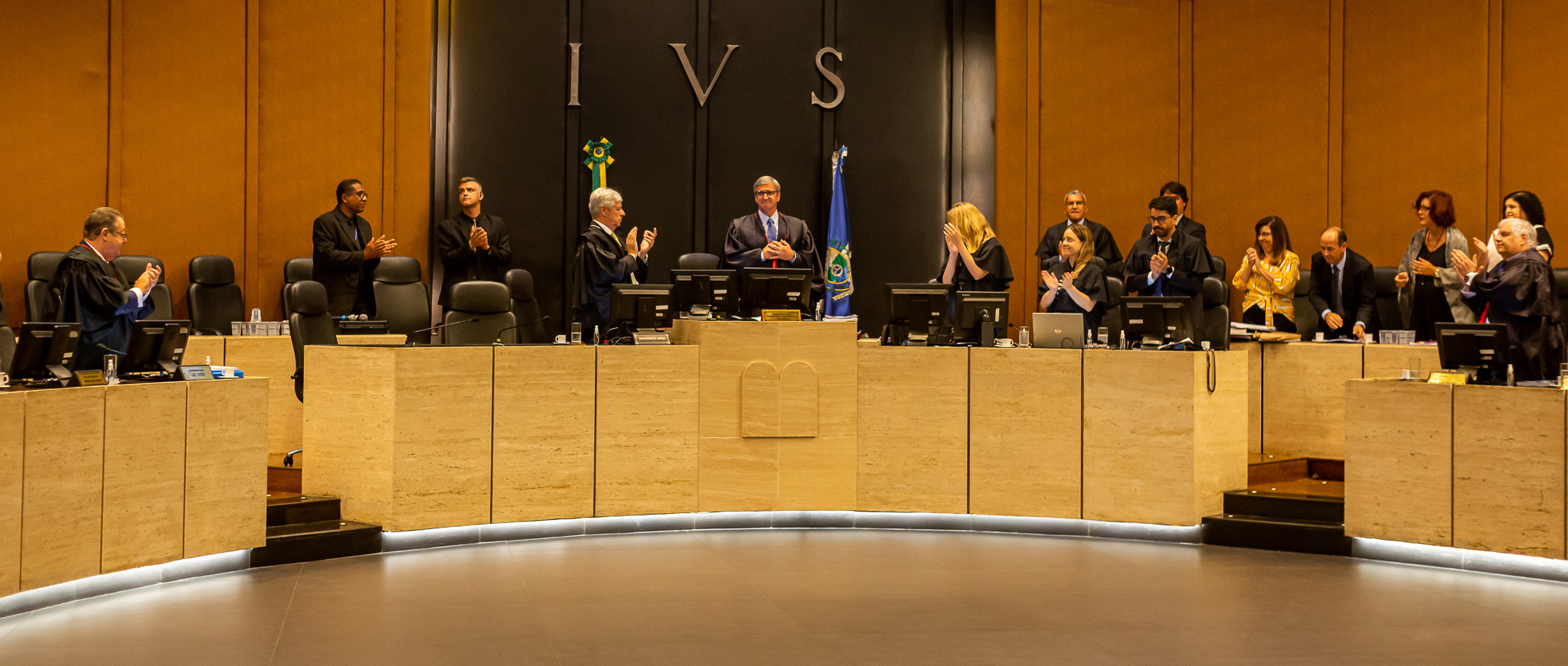 foto de magistrados e servidores aplaudindo de pé o presidente do TJRJ, des. Henrique Figueira, que está no centro do plenário do Órgão Especial