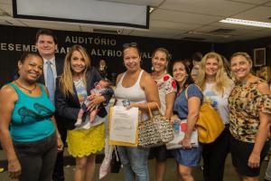 A bebê Maria Luisa dorme no colo da magistrada, ao lado da avó e da tia. O defensor público Bernardo Dias e a equipe da 2ª Vara também participaram da audiência que deu a guarda do bebê à avó