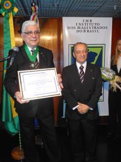 O corregedor-geral recebe a medalha de mérito pelas mãos do 2° vice-presidente do IMB, des. Roberto Cortes.