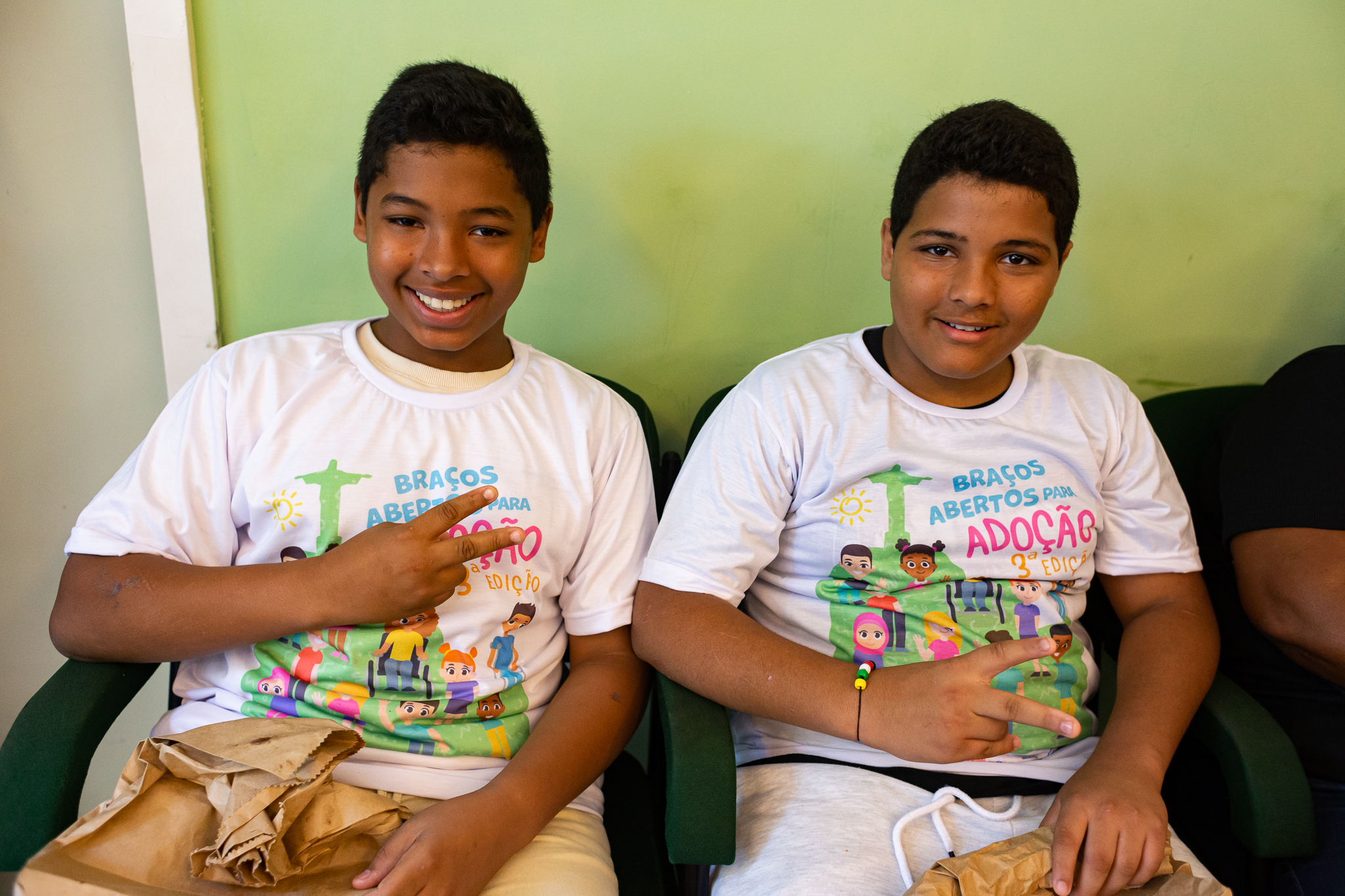 Sentados em cadeiras, irmãos Juan e Renan (vestidos com a camisa do evento)