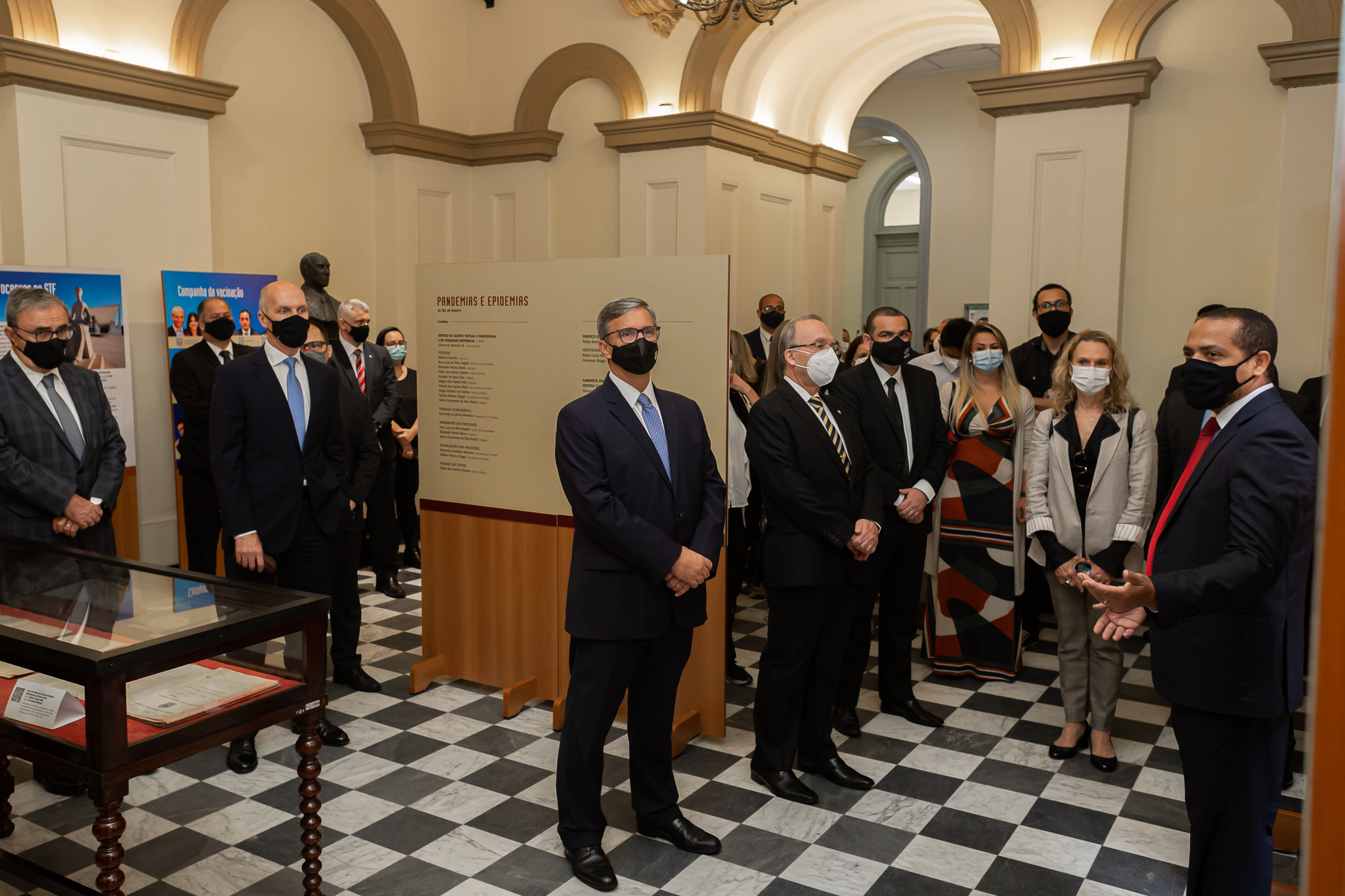 pessoas observam paineis da exposição. Presidente do TJRJ ao centro do Salão dos Passos Perdidos