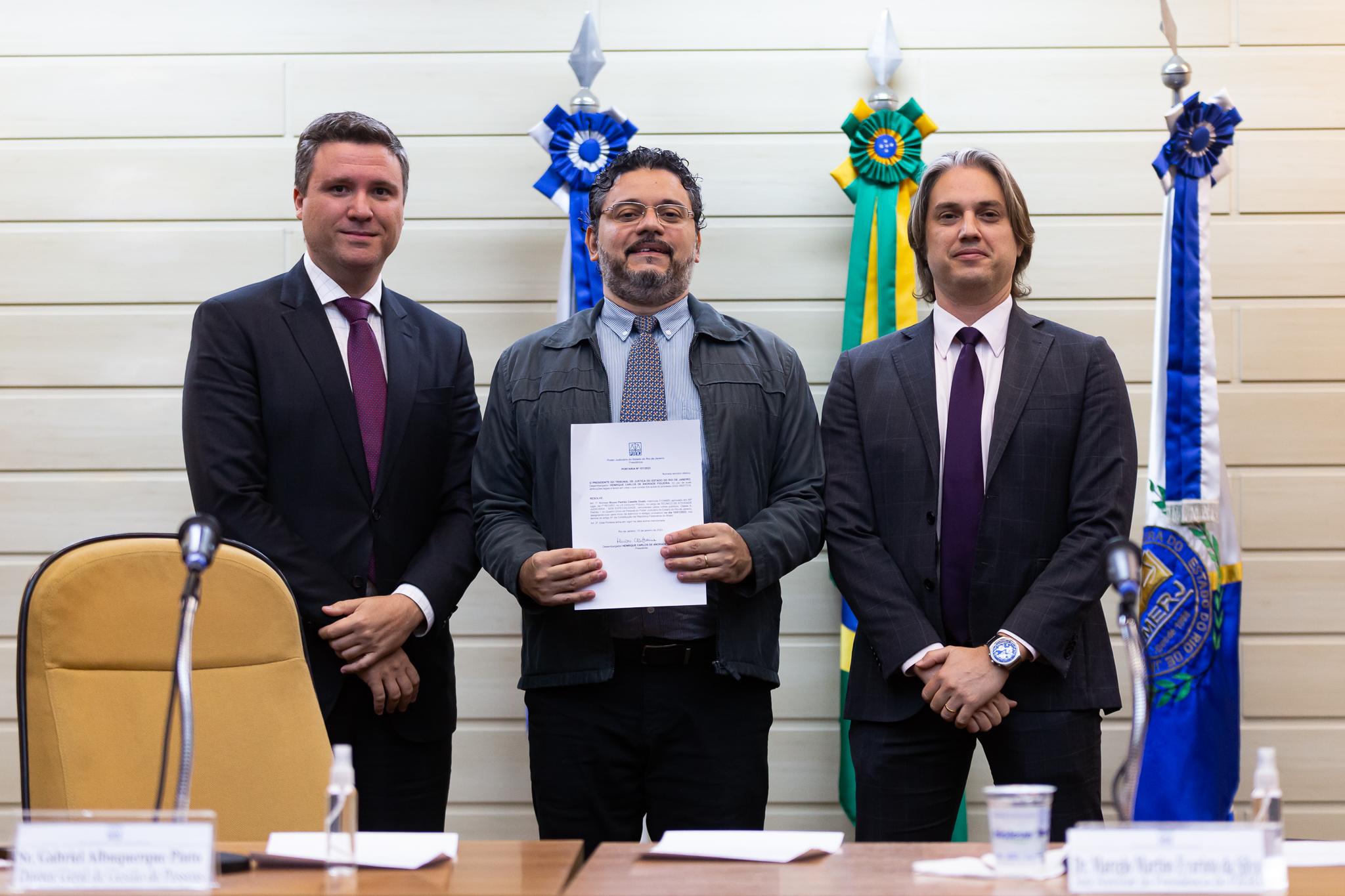 Imagem posada. Da esquerda para direita: diretor-geral de Gestão de Pessoas do TJRJ, Gabriel Albuquerque; Bruno Pedrão Giusti, novo servidor do TJRJ; e o juiz auxiliar da Presidência Marcelo Martins Evaristo da Silva