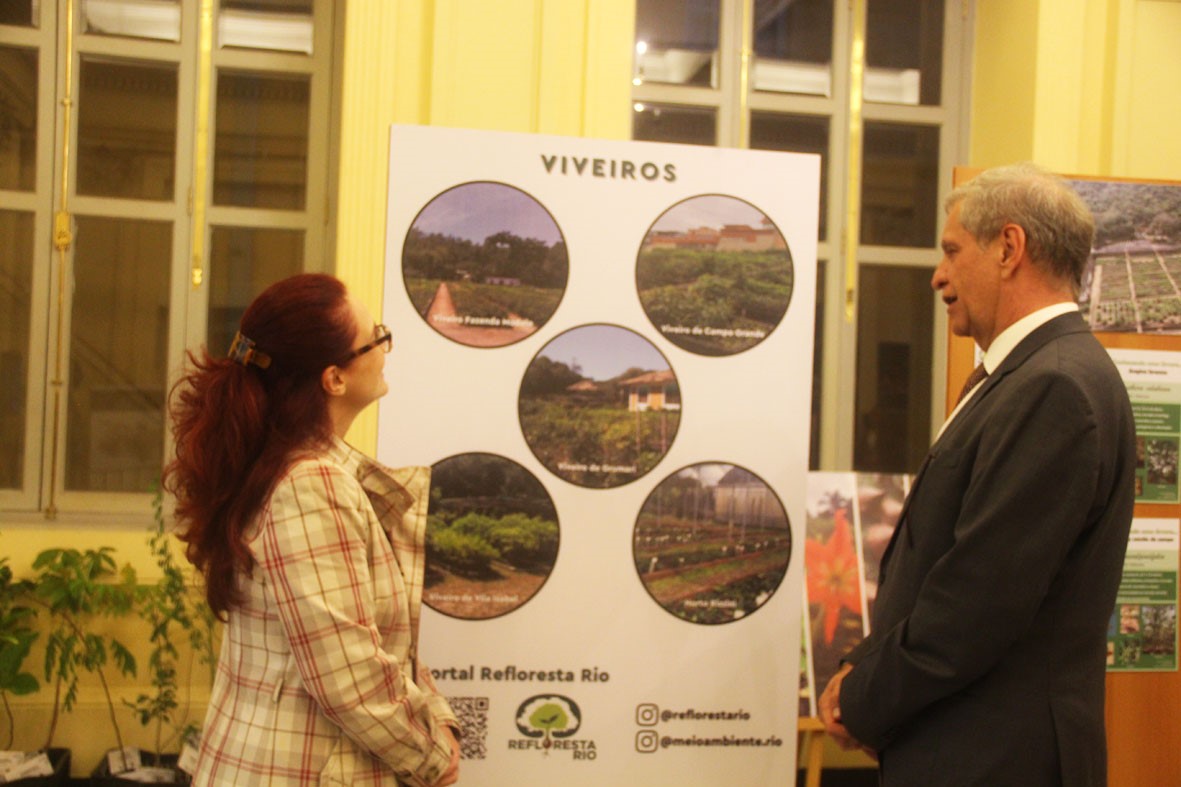 A juíza Admara Falante (à esquerda) e o desembargador Heleno Nunes (à direita) observam painel de fotos da exposição