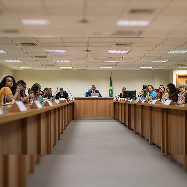 Foto sala de reunião com mesa em formato de 