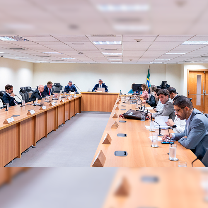 A imagem mostra cerca de 15 pessoas sentadas ao redor de uma mesa na reunião conduzida pelo desembargador Marcelo Anátocles e pelo juiz auxiliar da 2ª Vice-Presidência Marcello Rubioli.