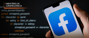 #ParaTodosVerem: Acima, no canto esquerdo, o título “EMENTÁRIO DE JURISPRUDÊNCIA”. A imagem mostra uma pessoa segurando um celular com o logotipo do Facebook exibido na tela. Ao fundo, há uma tela de computador com códigos de programação. 
