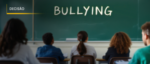 #ParaTodosVerem: Acima, no canto esquerdo, o título “EMENTÁRIO DE JURISPRUDÊNCIA”. Imagem de um quadro negro, tendo nele escrita a giz a palavra “BULLYING”. Não identificados e sentados de frente para o quadro, cinco alunos, sendo dois rapazes e três moças.