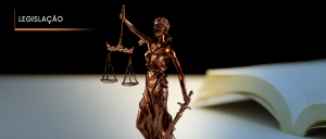 #ParaTodosVerem: Da esquerda para a direita, veem-se a estatueta representativa da Justiça e a lombada de quatro livros de Direito, sucessivamente, nas cores de capa branca, preta, marrom e verde.
