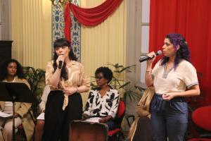 A museóloga Beatriz e a sua professora cantam no Troca de Livros em Homenagem a Adélia Prado