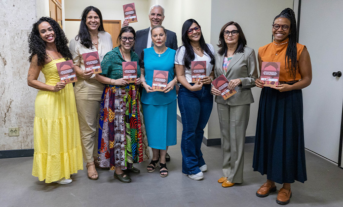 Tatiana Brandão (Napjus); Andrea de Lima (Napjus); a idealizadora da cartilha, Arethuza Doria; o presidente do Cogen - 1º grau, desembargador Wagner Cinelli; a 1ª vice-presidente do TJRJ, desembargadora Suely Lopes Magalhães; Alessandra Man-Fu (Napjus); a presidente do Cogen - 2º grau, desembargadora Patrícia Serra; Inara Flora Cipriano Firmino (Napjus) segurando a nova cartilha