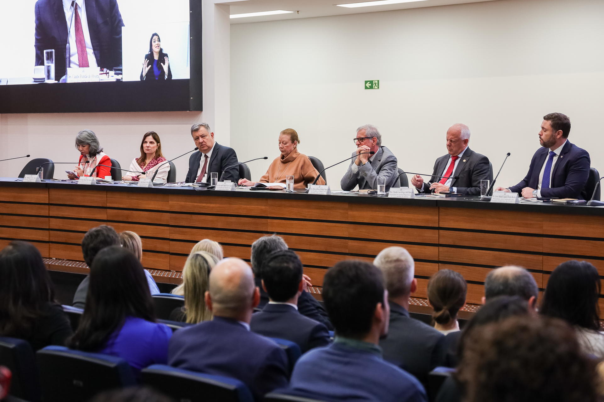 Imagem da mesa formada no evento. Da esquerda para direita:  desembargadora Márcia Alves Succi (Amaerj); presidente da Cojes, desembargadora Maria Helena Pinto Machado; Corregedor-Geral da Justiça, desembargador Claudio Brandão de Oliveira; 2ª vice-presidente do TJRJ, desembargadora Maria Angélica Guimarães Guerra Guedes; 3º vice-presidente TJRJ, desembargador Heleno Ribeiro Pereira Nunes; diretor-geral da Emerj, desembargador Cláudio Luis Braga Dell´Orto; e presidente da Comissão dos Juizados Especiais da OAB/RJ, Carlos Othoniel Guedes Pereira Botelho 