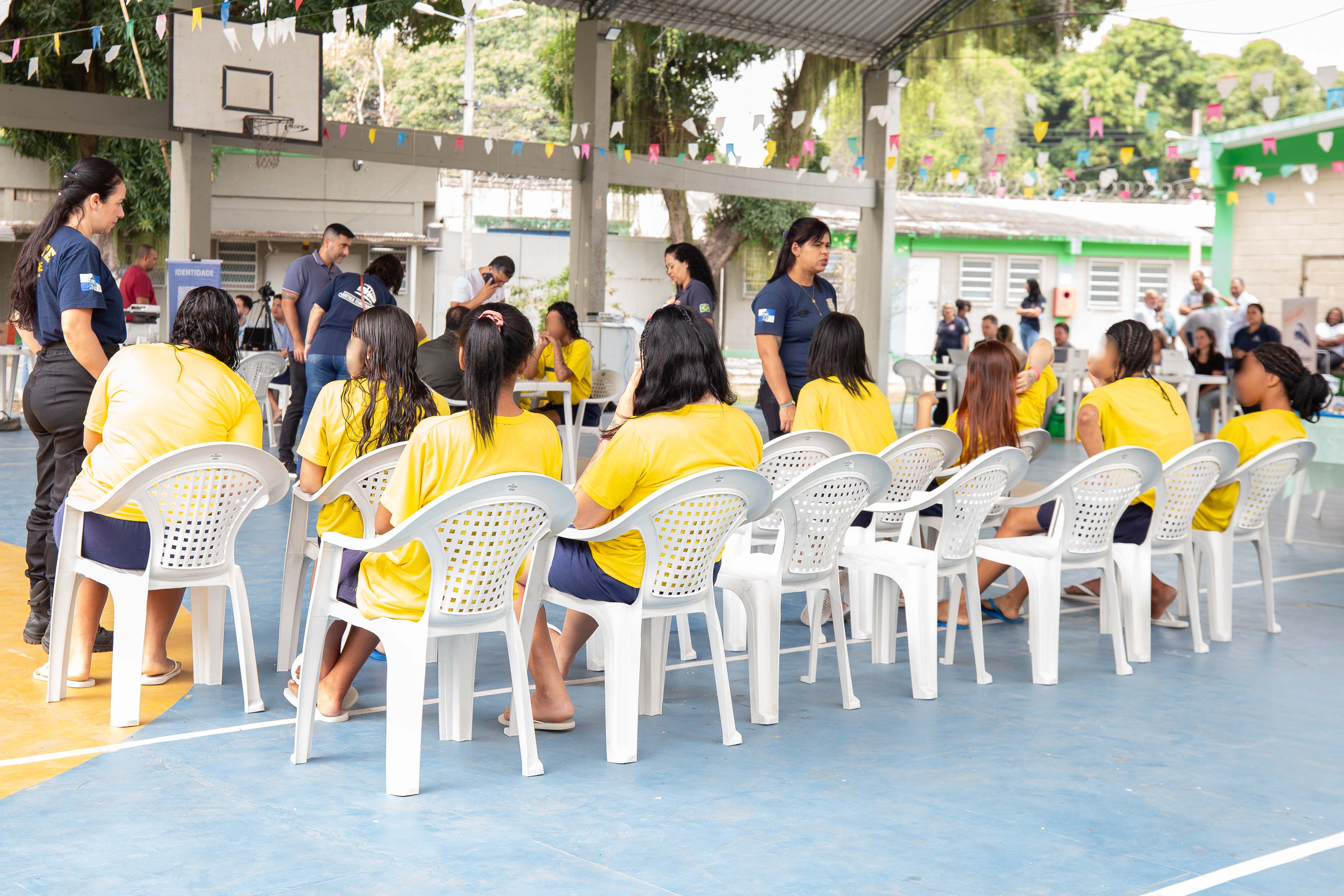 Jovens do Centro de Socioeducação Professor Antônio Carlos Gomes da Costa sentadas de costas aguardando atendimento do programa Justiça Itinerante