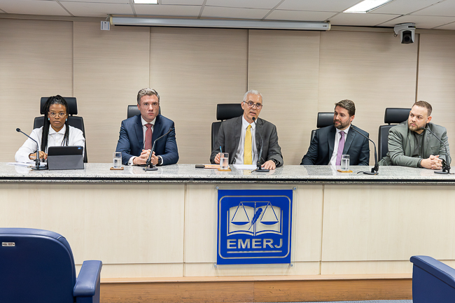 Imagem da mesa do evento. Da esquerda para direita: Da esquerda para a direita: a coordenadora do Napjus, Inara Firmino, o secretário-geral da SGPES, Gabriel Albuquerque Pinto, o desembargador Wagner Cinelli, o secretário-geral da SGDAI, Rodrigo de Oliveira Rocha e o diretor do Deige, George Gonzaga de Lima Silva 