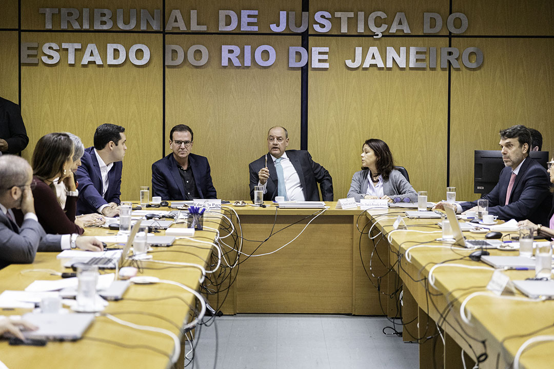 Imagem da reunião. Ao fundo, do lado esquerdo para o direito: prefeito do Rio, Eduardo Paes; presidente do TJRJ, desembargador Ricardo Couto de Castro; e desembargadora Daniela Brandão, presidente da Cevij