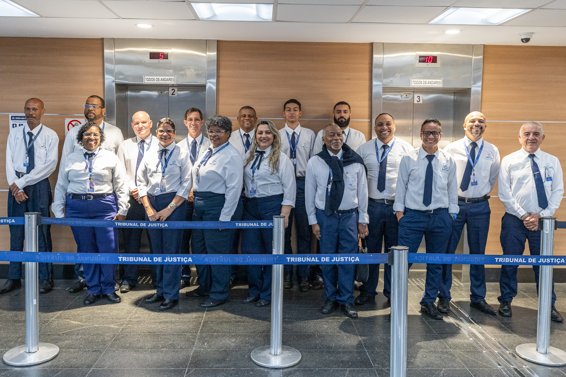 Grupo de ascensoristas posam na entrada dos elevadores do Fórum Central