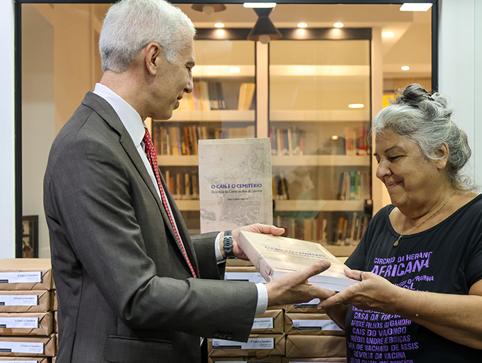 Desembargador Wagner Cinelli entrega exemplar do livro à diretora-presidente do Instituto Pretos Novos (IPN), Merced Guimarães dos Anjos