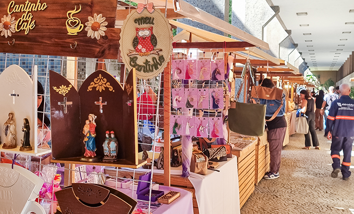 A imagem mostra várias barracas montadas expondo produtos de artesanato. 