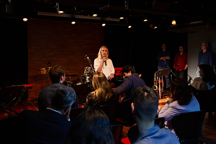 A imagem mostra a Sala Multiuso lotada com a desembargadora Cristina Gaulia conversando com o público