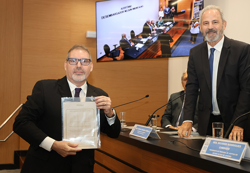 Desembargador Sérgio Seabra Varella entregando a Declaração de Publicação ao servidor que participou da 1ª edição da "ESAJ Acadêmica".